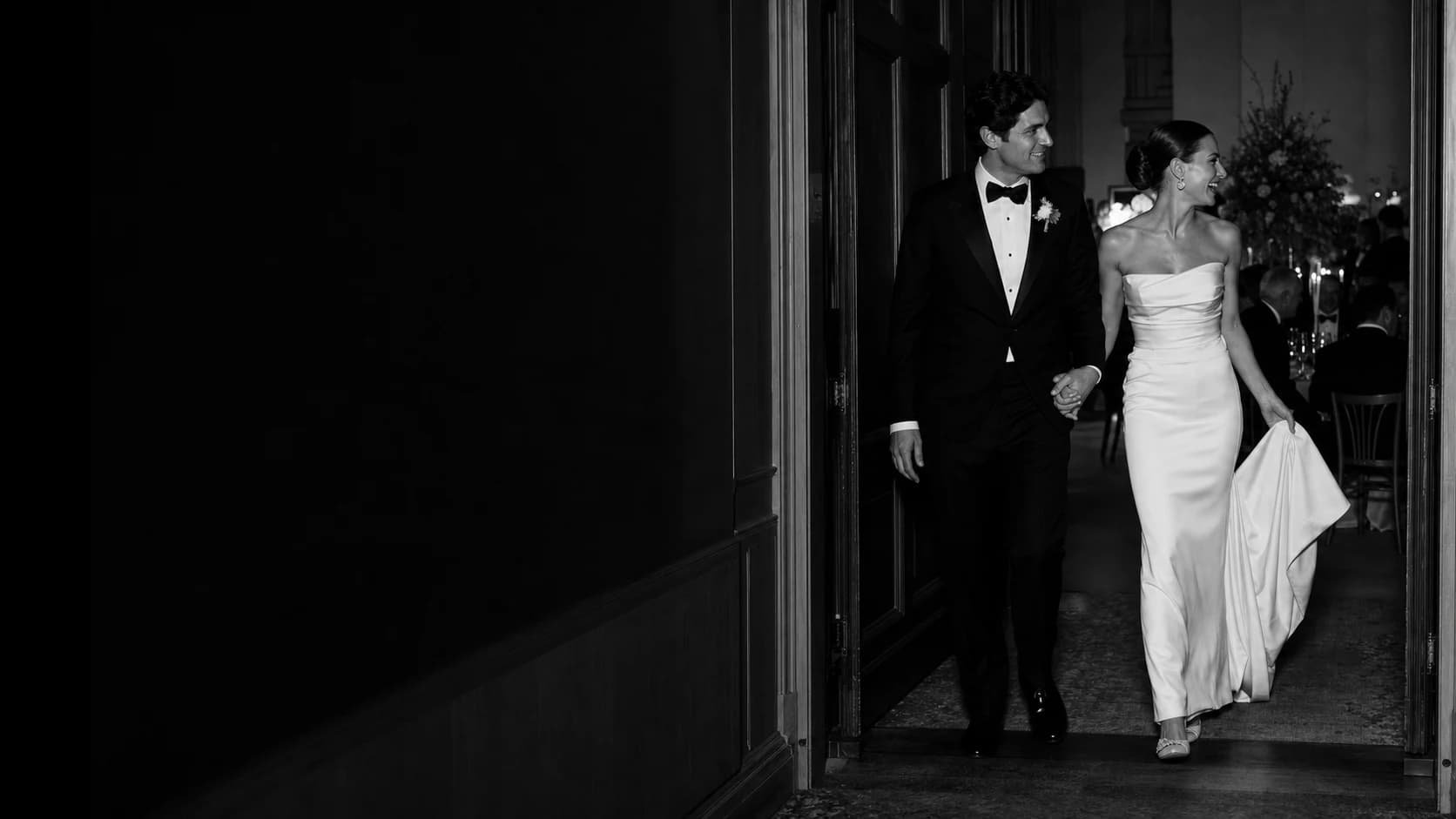 A black-tie couple entering an evening wedding reception
